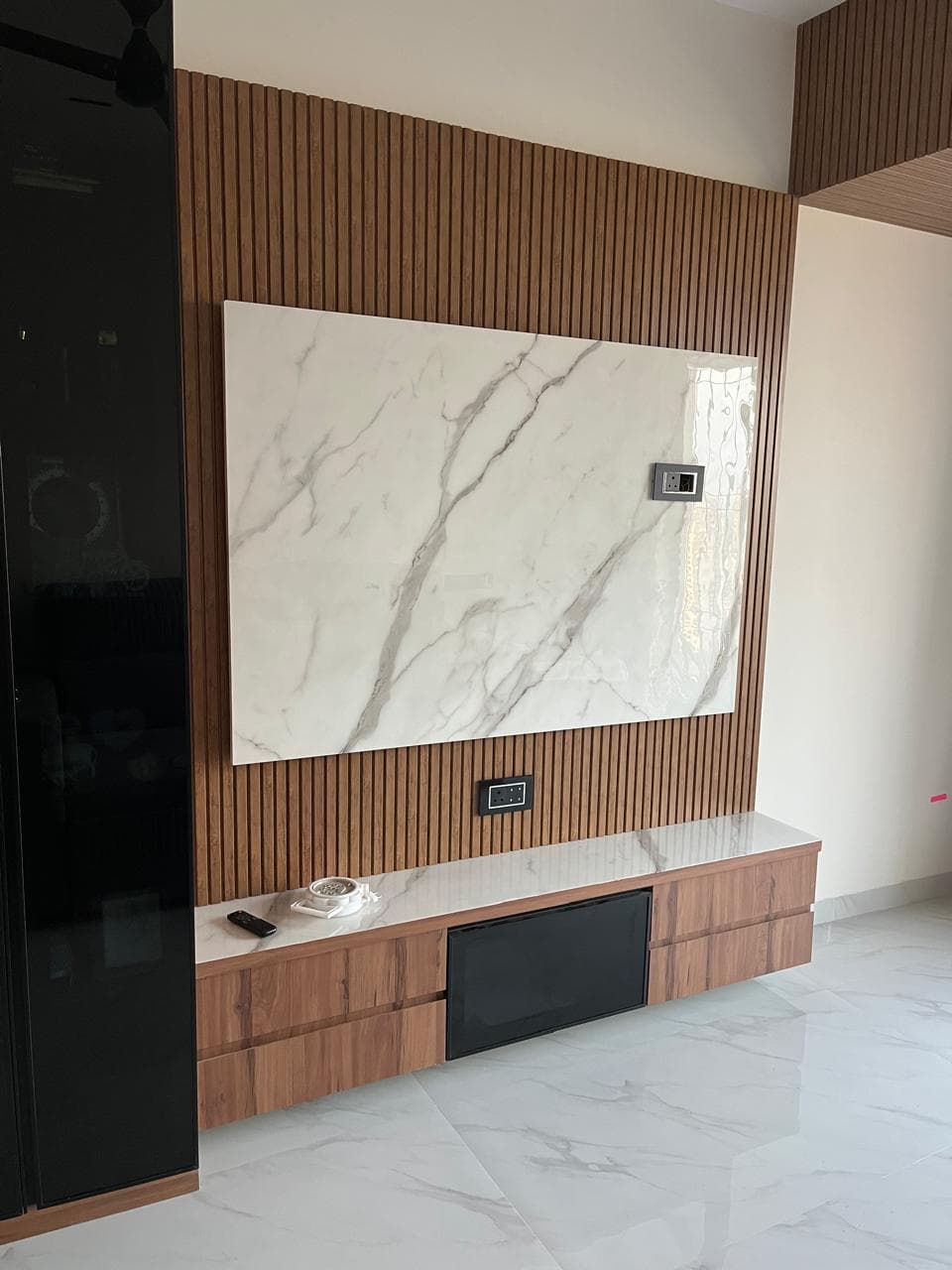 Fluted wood TV unit with marble backdrop
