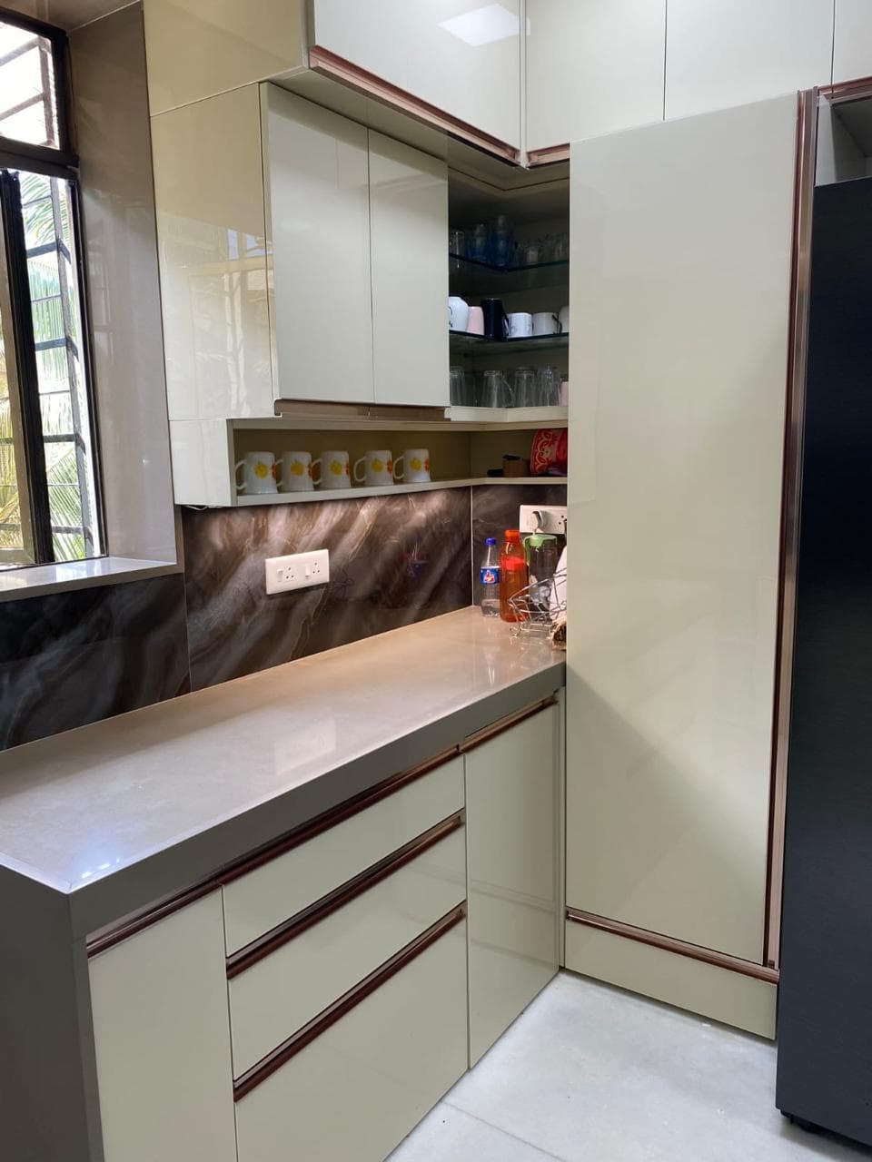 Cream gloss kitchen with rose-gold profiles